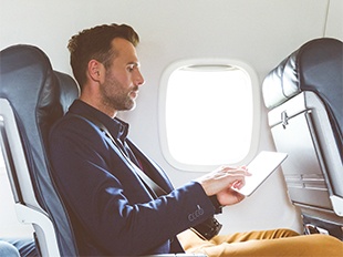 mann am tablet im flugzeug