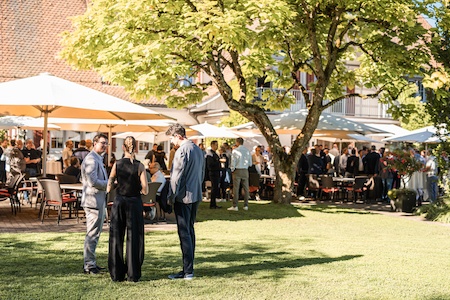 Gäste beim Networking im Garten des Zucchetti Forum 2025 in Widenmoos – lockere Gespräche und inspirierende Atmosphäre bei strahlendem Sonnenschein